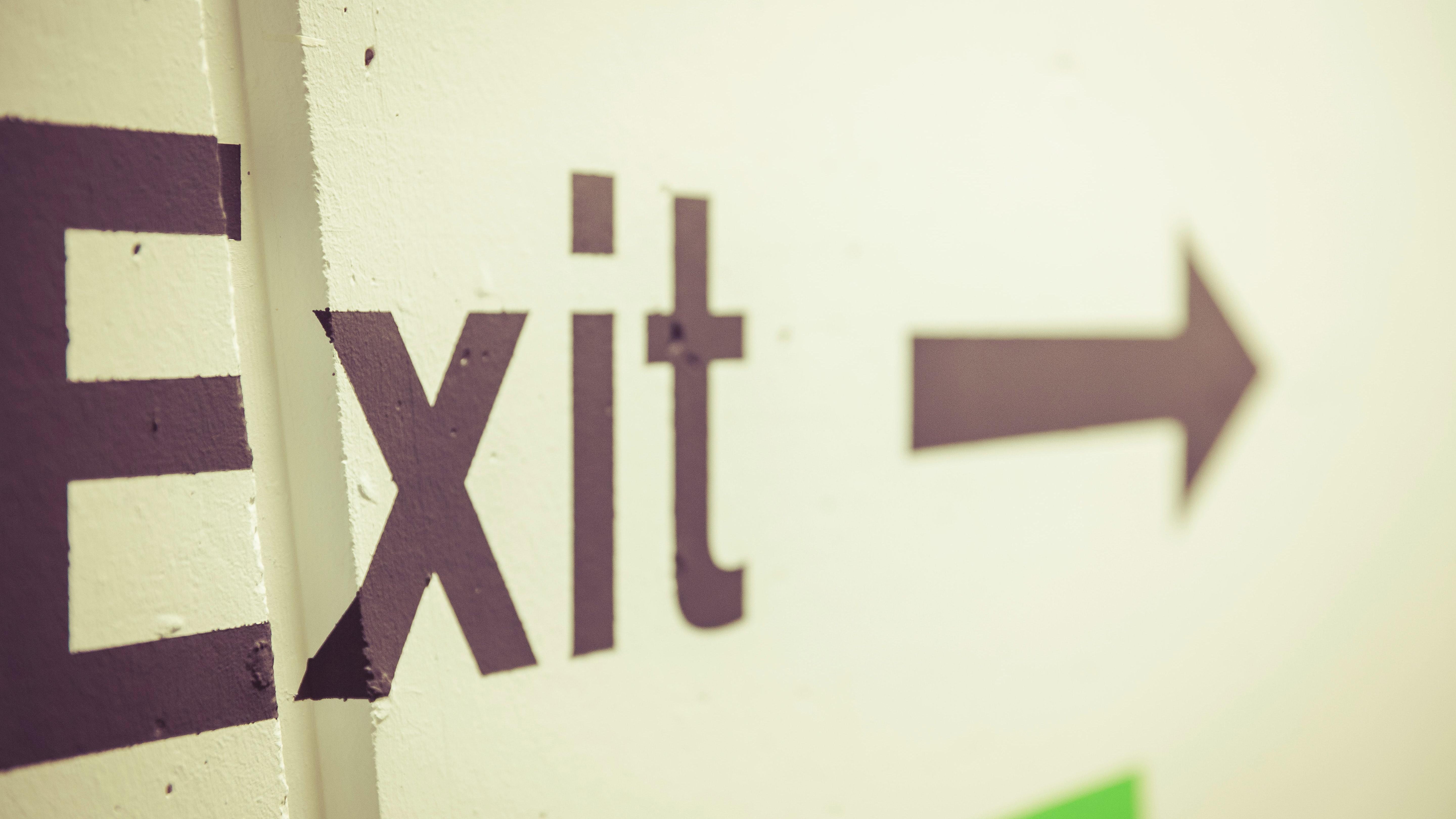Bild: Das Wort Exit und ein Pfeil auf einer Wand